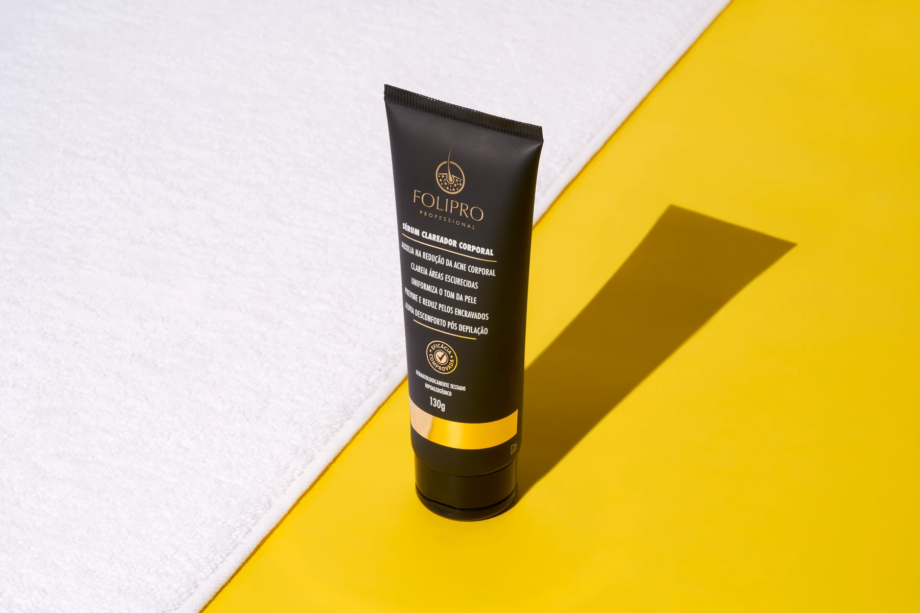 Sérum Clareador Corporal Folipro sobre toalha e fundo amarelo